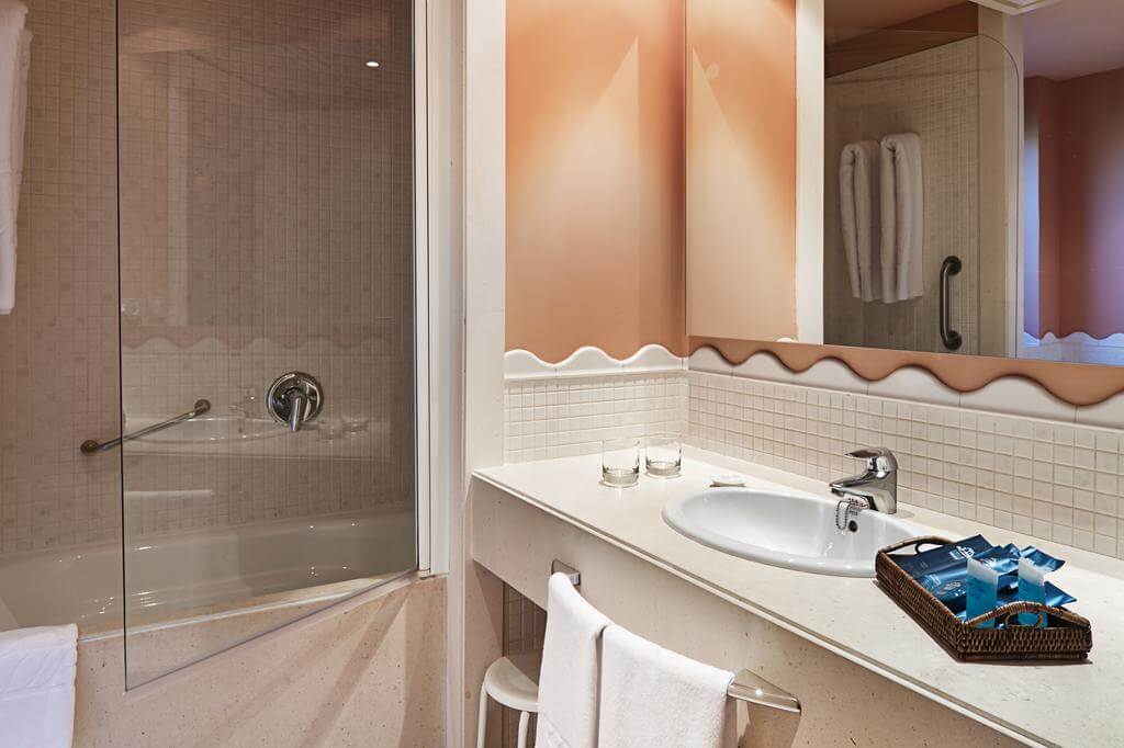 Bathroom with bath, shower, sink and toiletries at DoubleTree by Hilton Islantilla Beach Golf Resort