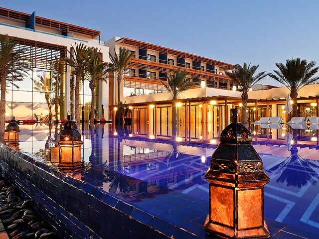 Sofitel Essaouira Mogador Golf And Spa at night, overlooking the swimming pool and palm trees