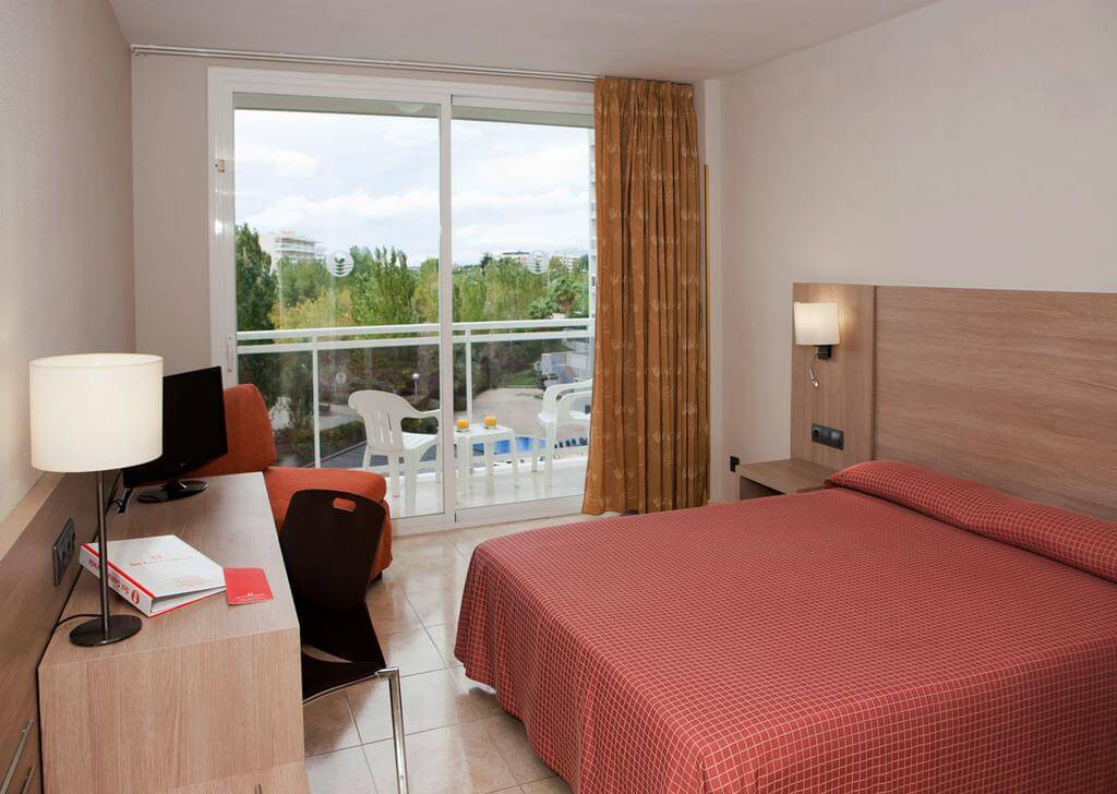 Bedroom with double bed and private balcony at Sol Costa Daurada By Melia