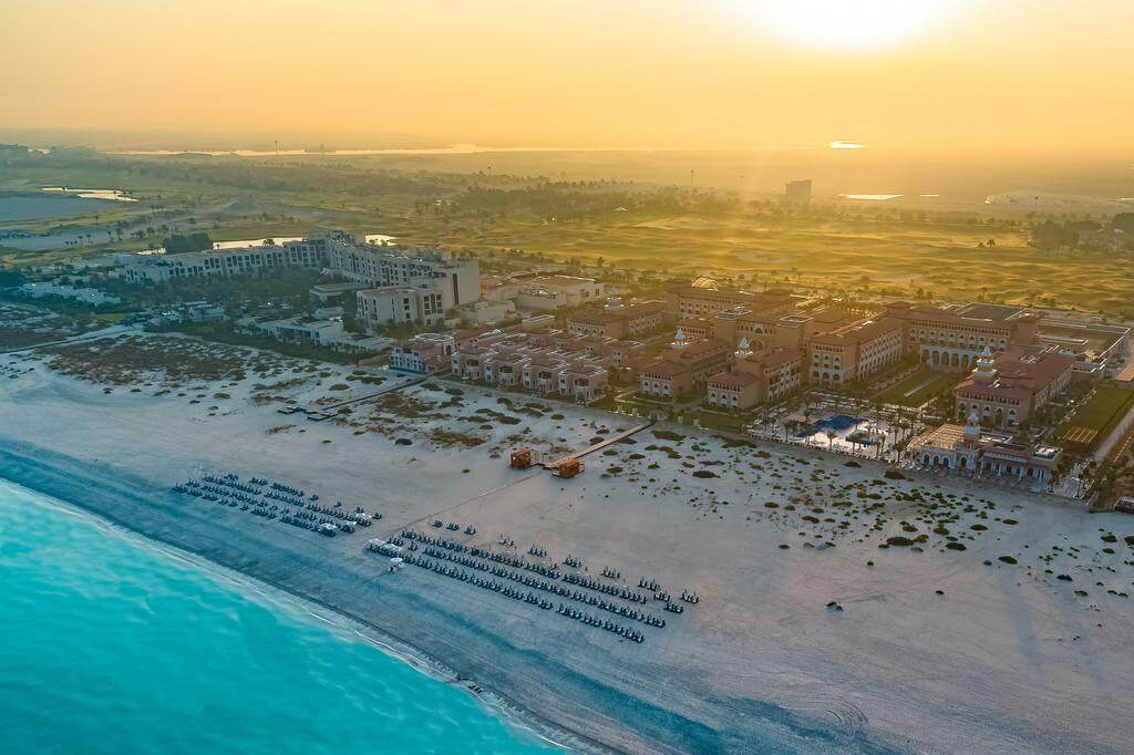 Rixos Saadiyat Island Abu Dhabi at dawn overlooking the beach, sun loungers, blue sea and sand