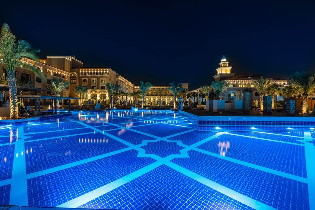 Rixos Premium Saadiyat Island at night overlooking the palm trees and swimming pool