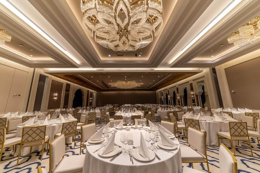 Rixos Premium Saadiyat Island dining room with gold trimmed chairs, dining tables, and tables set with cutlery