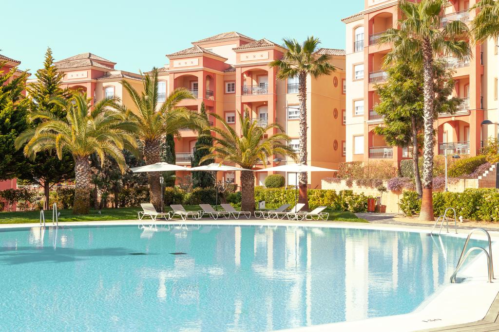 Swimming pool and sun lounge area at The Residences Islantilla Apartments