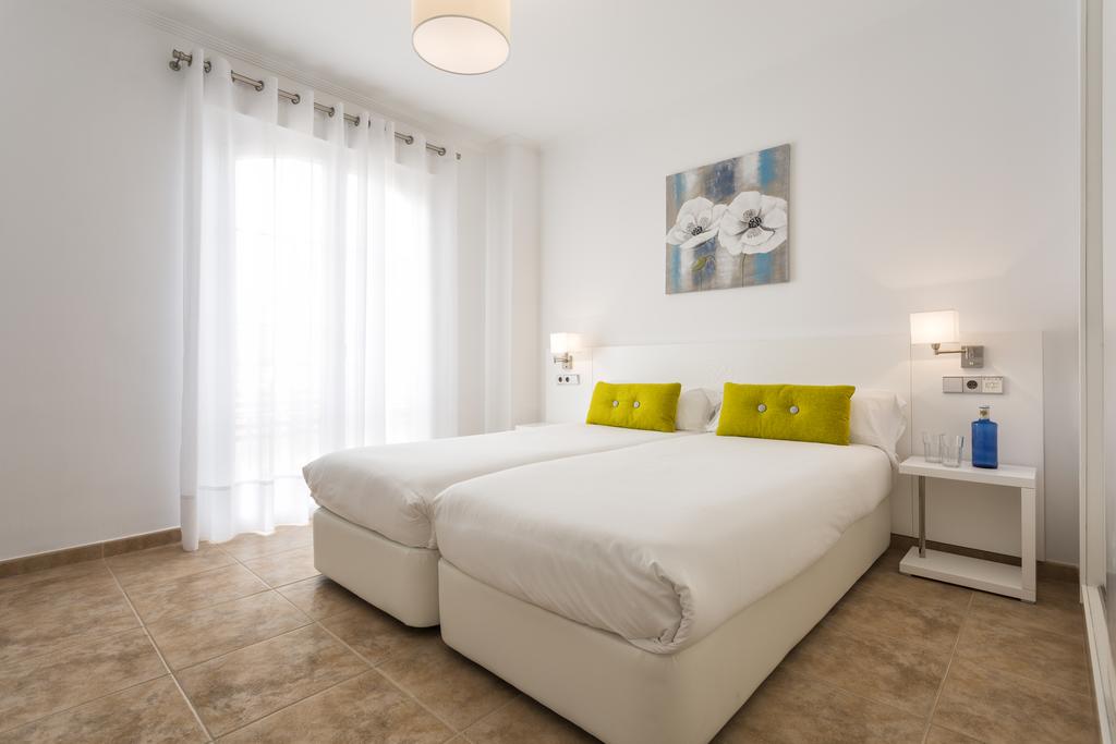 Twin bedroom with bedside tables and lamps at The Residences Islantilla Apartments