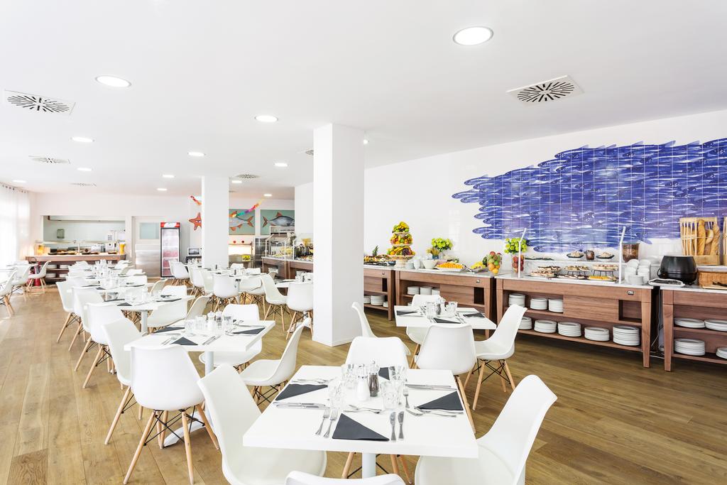 Restaurant serving breakfast with white dining furniture at The Residences Islantilla Apartments