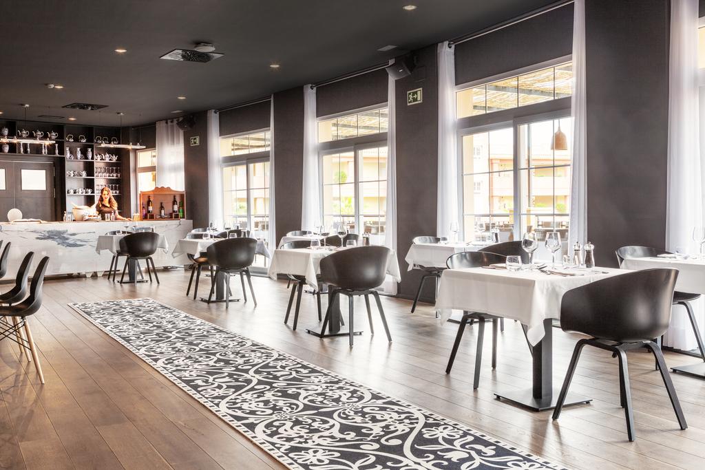 Restaurant with black dining furniture and bar at The Residences Islantilla Apartments