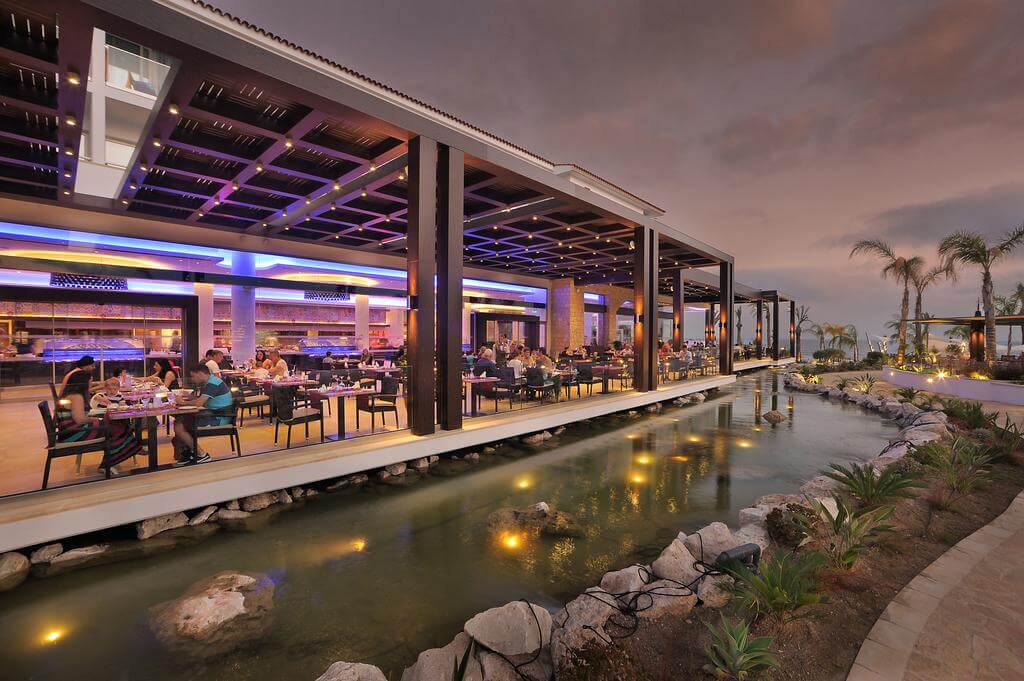 Olympic Lagoon Resort Paphos bar in the evening with illuminated stream alongside it