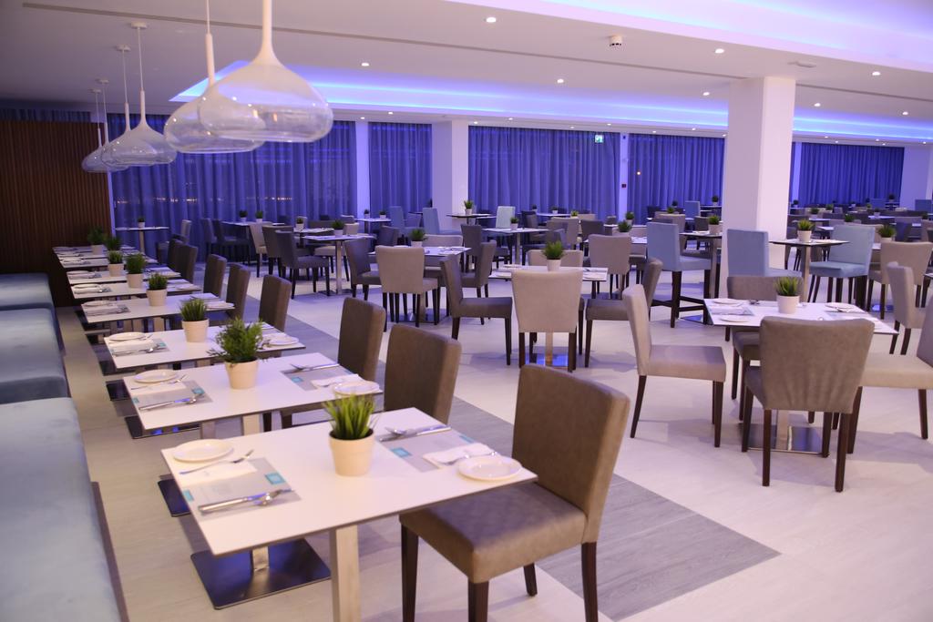 Restaurant at St. George Hotel Spa And Golf Beach Resort with tables set and green plant on each table