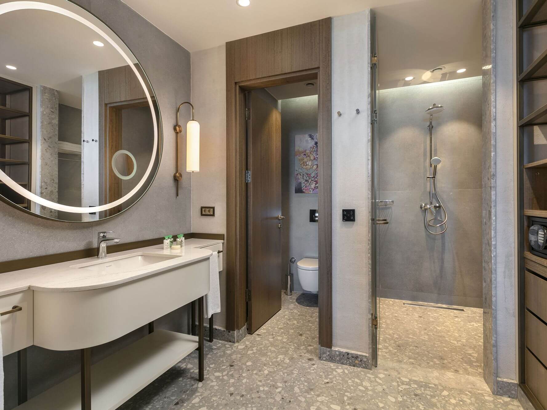 Bathroom at Cullinan Belek with separate toilet and shower cubicles, round mirror and sink