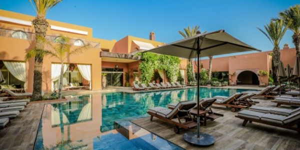 Tikida Palace Golf swimming pool with blue sky, sun loungers and parasol