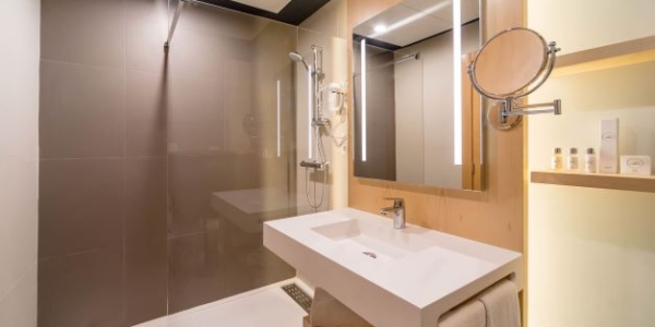 Bathroom at Hotel Occidental Murcia Siete Coronas with mirror on the wall, shower unit, sink and clean white towels