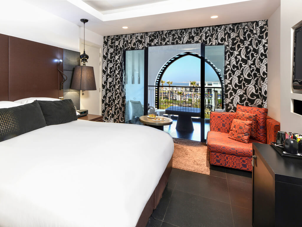 Bedroom with double bed, orange chair and mounted television at Hotel Sofitel Thalassa Sea And Spa