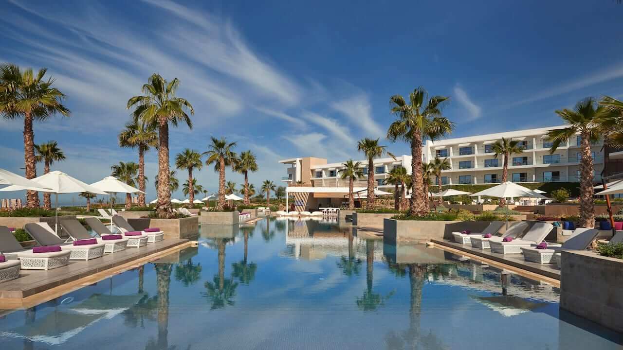 Outdoor swimming pool and palm trees at Hyatt Place Taghazout Bay