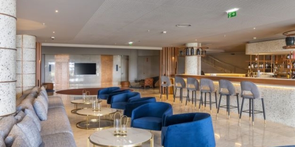 Bar area with stools and blues seats at NEXT by Savoy Signature in Madeira