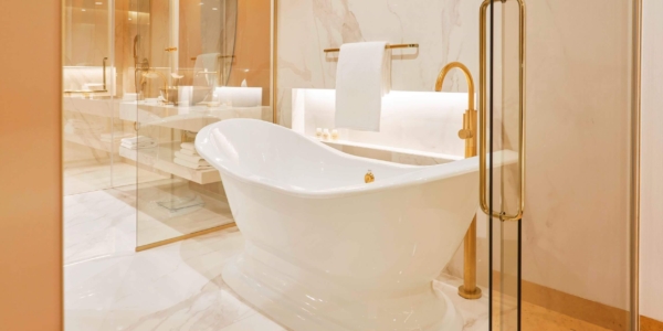 Bathroom in Savoy Palace in Madeira. White bathtub with gold taps and seperate shower unit