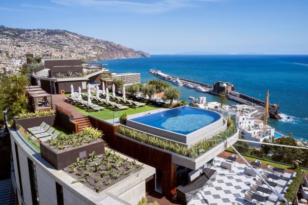 View of the rooftop at Savoy Palace hotel in Funchal, Madeira with swimming pool and sun loungers overlooking the harbour