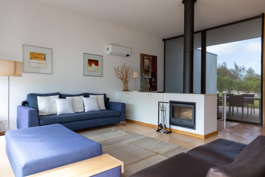 Living room at Bom Sucesso Resort in Lisbon with blue sofa and fireplace