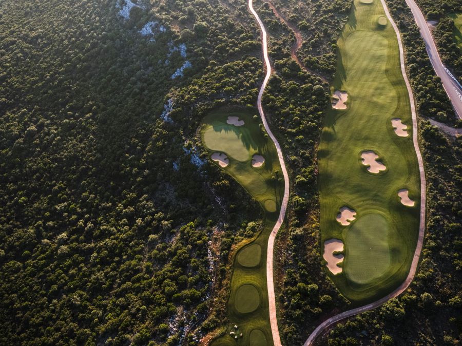 Drone shot of trees and woodland, buggy path, and fairway at International Olympic Academy Golf Course