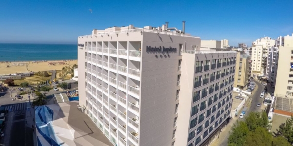 Exterior of Jupiter Algarve Hotel in Portimao with blue sea and clear blue sky in background