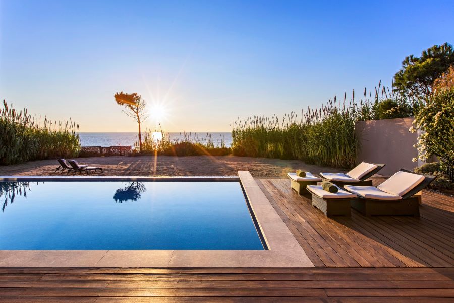 Swimming pool with sun setting at The Ramanos, A Luxury Collection Resort in Costa Navarino