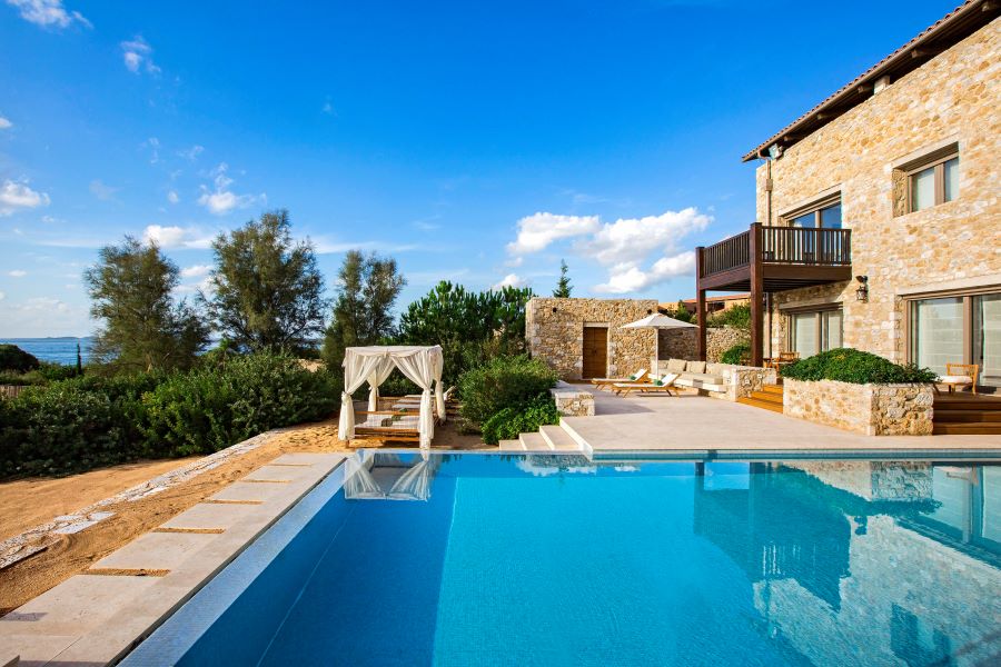 Swimming pool with Bali bed and loungers at The Ramanos, A Luxury Collection Resort in Costa Navarino