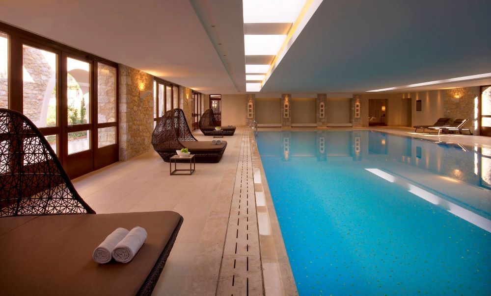Indoor swimming pool with sun loungers at The Westin Resort Costa Navarino