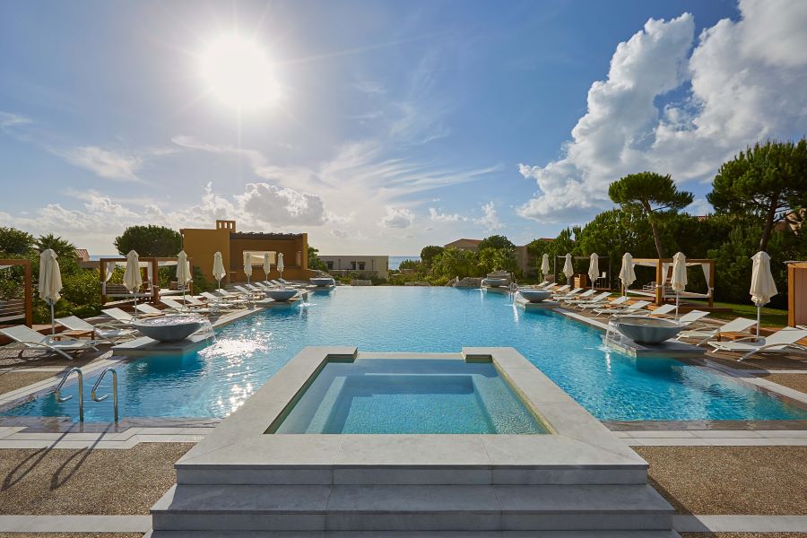 Swimming pool with spa pool at centre with sun loungers either side at The Westin Resort Costa Navarino