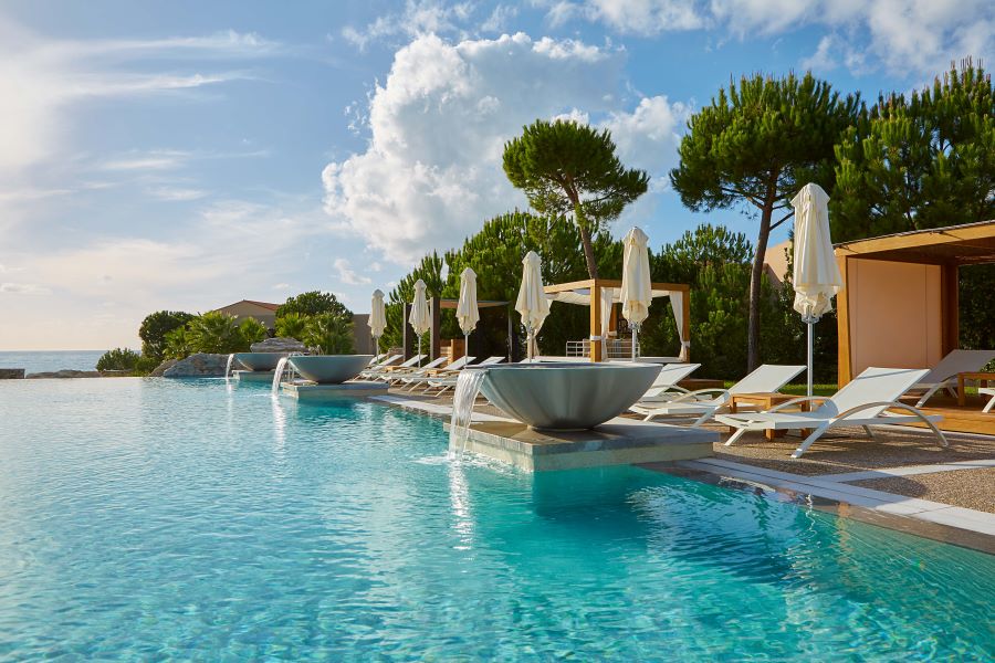 Swimming pool with sun loungers at The Westin Resort Costa Navarino