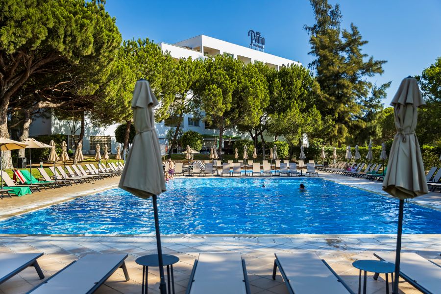 The Patio Suite Hotel Albufeira swimming pool with sun loungers and parasol
