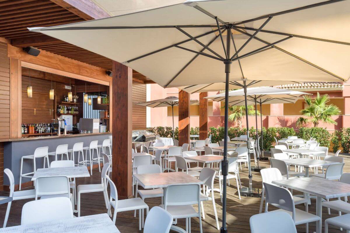 White tables and seats at outdoor area in AMA Islantilla Resort
