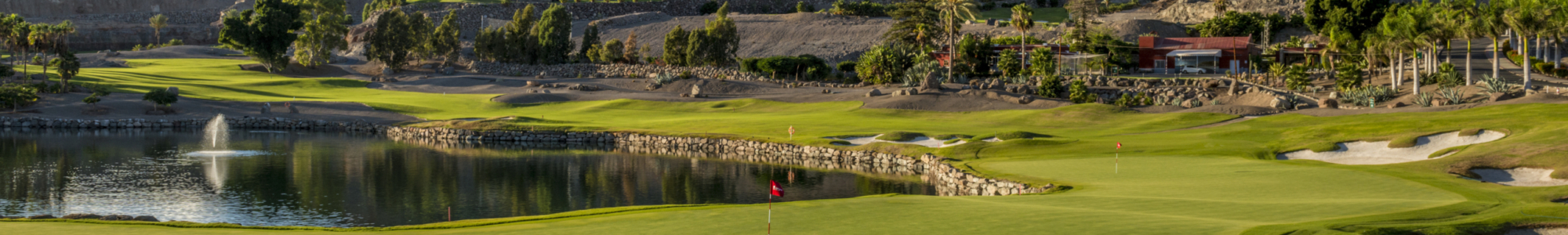 Wide shot of a gran canaria golf course showing the fairway with the green and mountains in the background