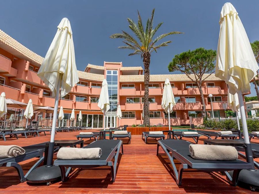 Sun loungers and palm tree by the pool at Vilamoura Garden Hotel