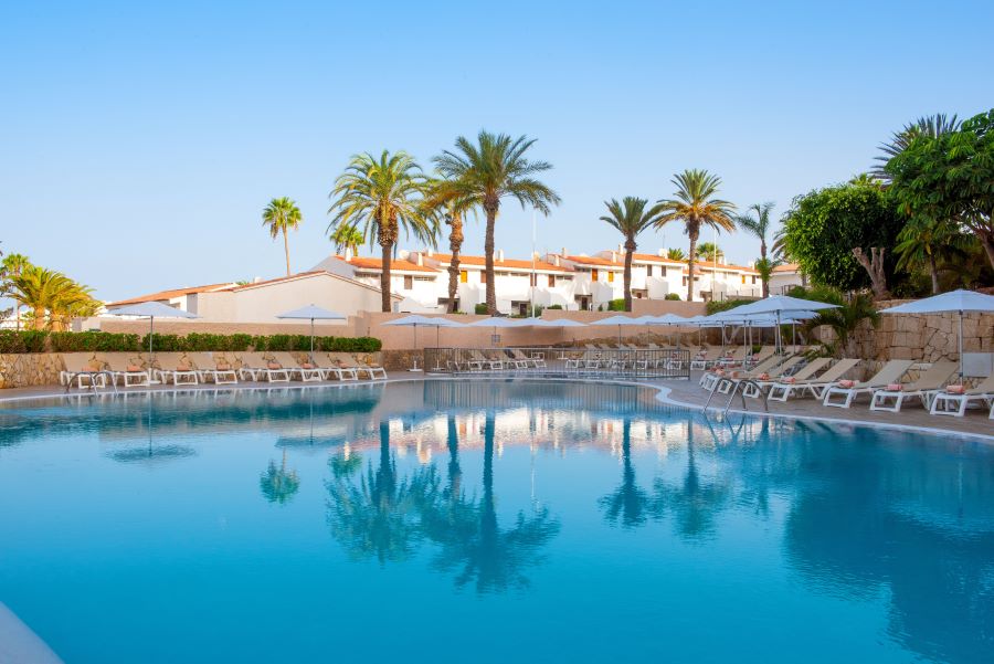 Ole Tropical Tenerife swimming pool with palm trees overlooking and blue skies overhead