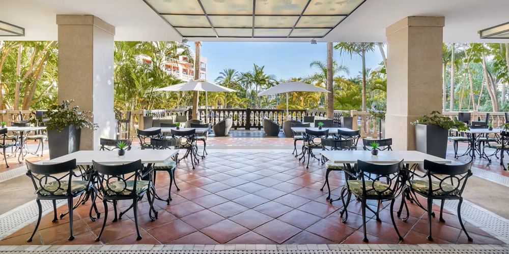 Tiled floor with tables and chairs at Barcelo Marbella Hotel