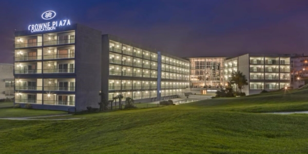 Crowne Plaza Caparica hotel in Lisbon on an evening with dark sky and lights on