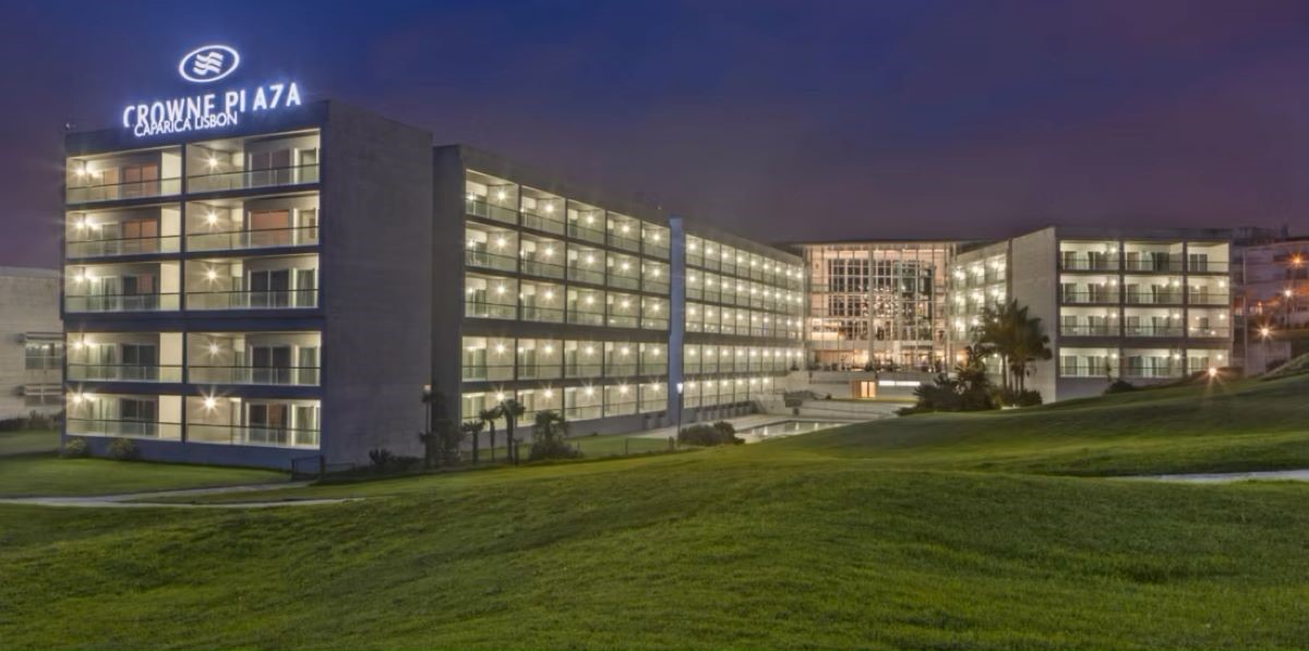 Crowne Plaza Caparica hotel in Lisbon on an evening with dark sky and lights on