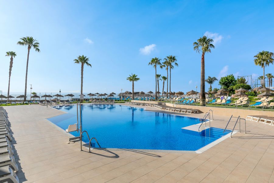 Swimming pool with palm trees around the outside at Sol Puerto Marina