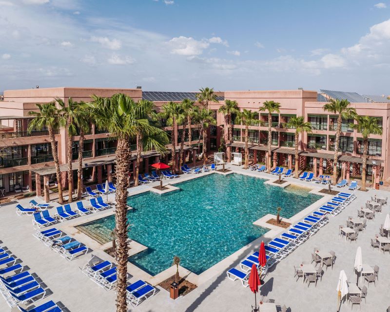 Palm trees overlooking the pool with sun loungers surrounding at Pickalbatros Hotel Du Golf Palmeraie Marrakech