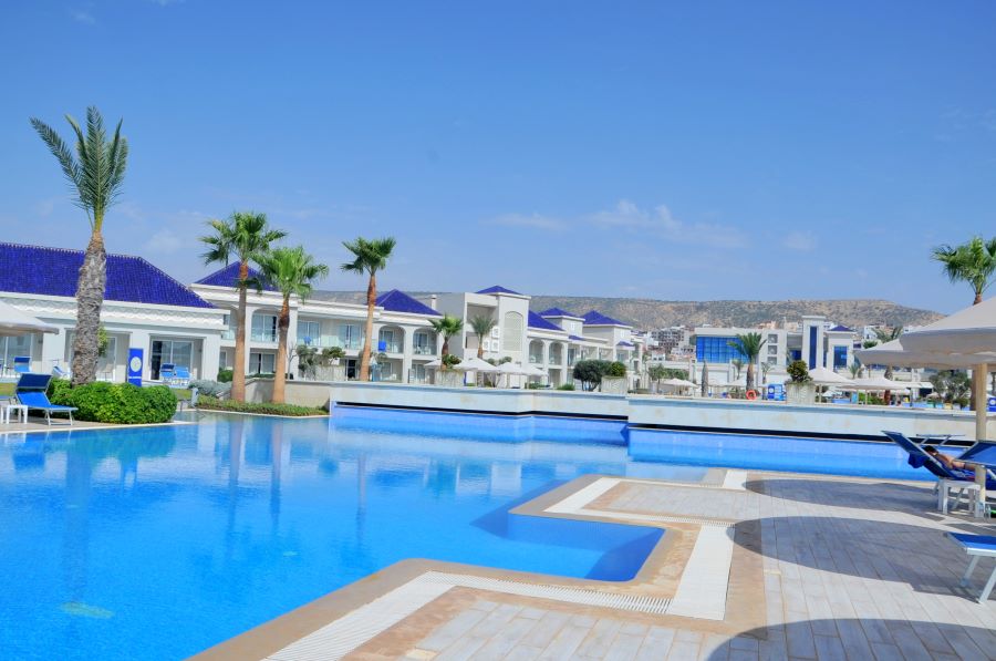 Large outdoor pool with palm trees overlooking at Pickalbratros White Beach Taghazout Resort