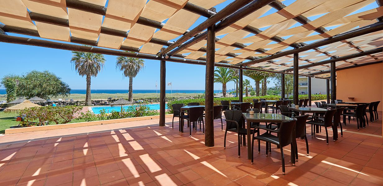 Patio area at Dom Pedro Lagos Hotel with tables and chairs