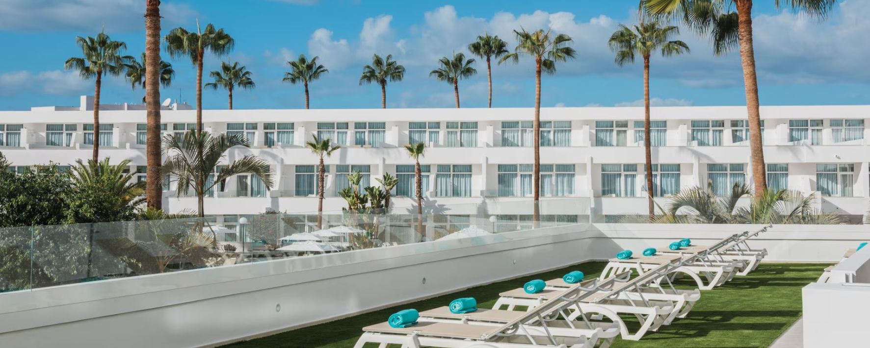 Sun loiungers on terrace with palm trees over Iberostar Waves Las Dalias