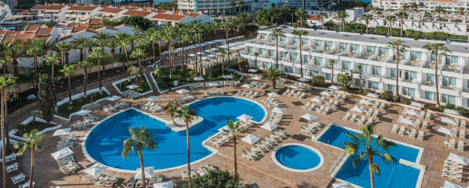 Overhead shot of Iberostar Waves Las Dalias in Tenerife, with swimming pool surrounded by sun loungers and palm trees
