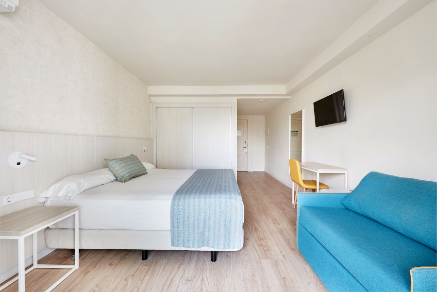 Bedroom with double bed and television on the wall at Hotel Palmasol Benalmadena