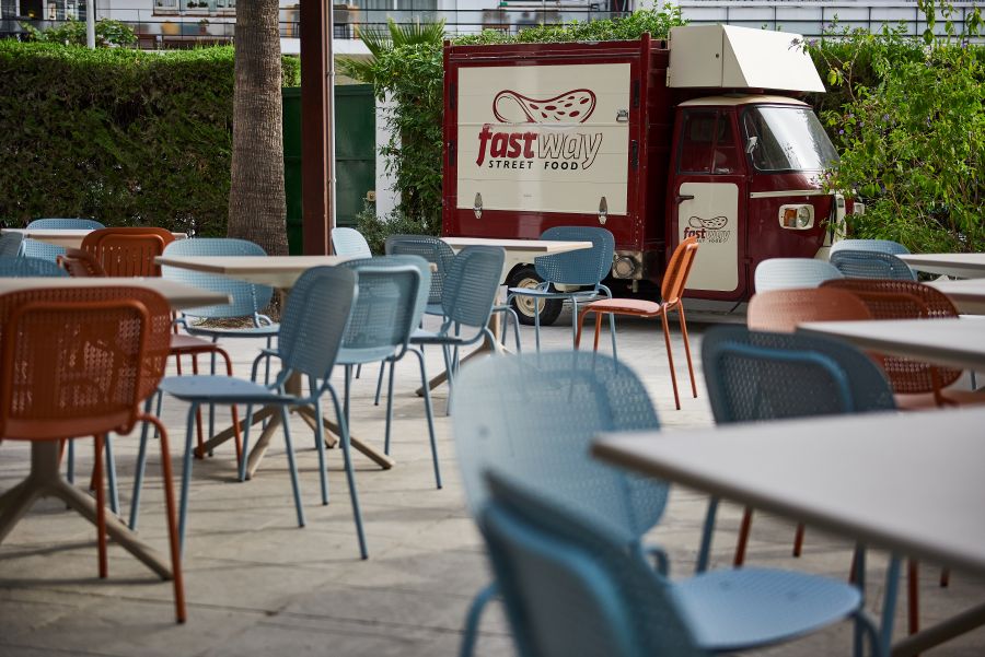 Blue chairs in outdoor seating area and dining truck at Hotel Palmasol